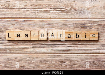 learn arabic word written on wood block. learn arabic text on table, concept. Stock Photo