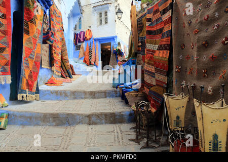 Typical handmade rugs exposed for sale on a street in Chefchaouen, Morocco