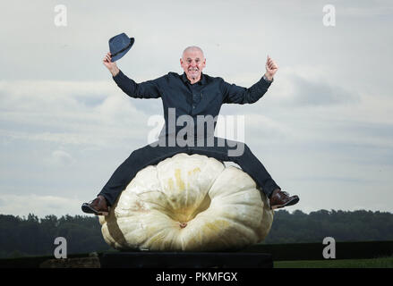 Graham Barratt with his winning heaviest in class giant pumpkin weighing 319.8kg during the Giant Vegetable competition at the Harrogate Autumn Flower Show in Yorkshire. Stock Photo
