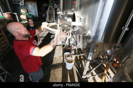 Davenport, Iowa, USA. 14th Sep, 2018. Great River Brewery owner and brewer Scott Lehnert, left finishes cleaning a fermenting tank as he talks with Quad-City Times reporter Amanda Hancock about the brewing process Friday, September 14, 2018. Credit: Kevin E. Schmidt/Quad-City Times/Quad-City Times/ZUMA Wire/Alamy Live News Stock Photo