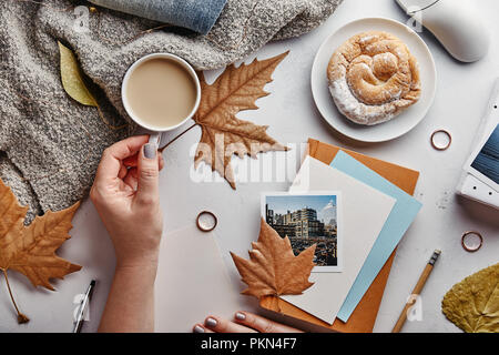 Autumn flat lay concept. Woman’s home office desk with coffee and autumn leaves. Top view Stock Photo