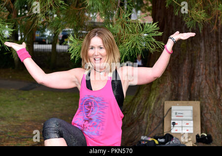 Female instructor leading an outdoor Zumba class for children, Alton, Hampshire, UK. Friday 31 August 2018. Stock Photo