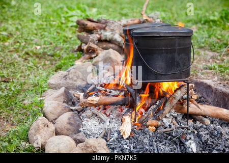 Camping kettle over burning campfire Stock Photo - Alamy