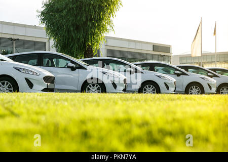 Row of brand new white cars in stock at the car dealership. Unsold cars for sale. Stock Photo