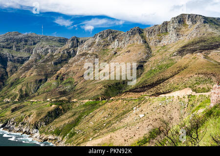Road through craggy rocky slopes with bushes, South Atlantic ocean, Chapman's Peak Drive, South Africa Stock Photo