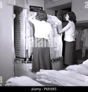 1950s, historical, hoisery, two ladies using a machine to test and