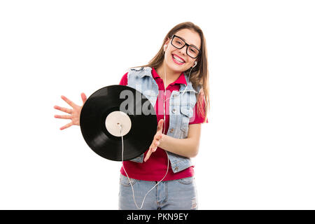 Young cheerful woman in glasses holding vintage vinyl recorded with headphones smiling at camera isolated on white background Stock Photo