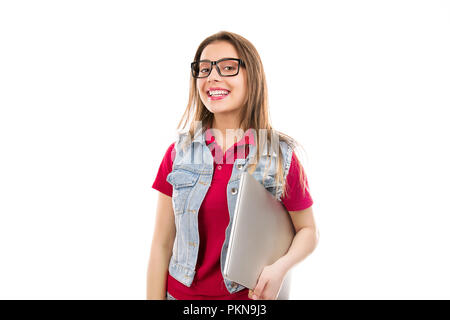 Pretty young woman in eyeglasses holding laptop and smiling at camera isolated on white background Stock Photo