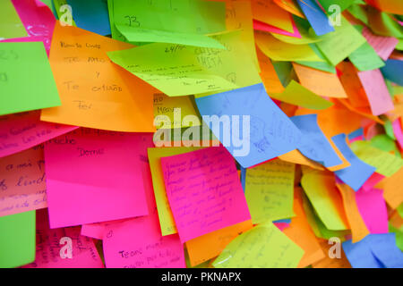 QUITO, ECUADOR - AUGUST 24, 2018: Close up of selective focus of exposition of set of colorful paper notes in a wall, in the city of Quito Stock Photo