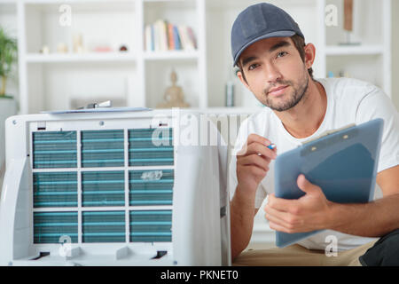young male technician checking digital photocopier machine Stock Photo