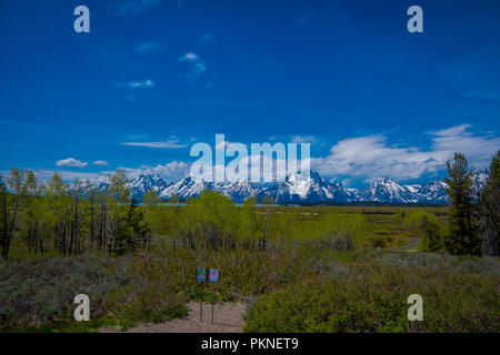 YELLOWSTONE, MONTANA, USA MAY 24, 2018: Close up of informative sign of Teton range and the valley mountains landscape of Grand Teton National Park, Wyoming behind Stock Photo