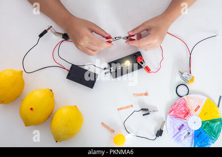 Children's hands doing experiments in isolated white background Stock Photo