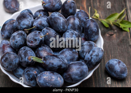 Plums in a plate on a dark table Stock Photo