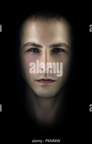 Contrasting male portrait on black background. Light and shadow on the man's face. Stylish, brutal man, art photo. Silhouette face serious macho, expr Stock Photo