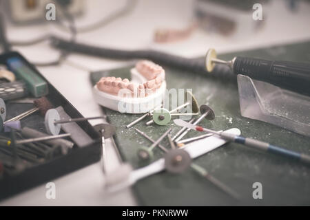 Artificial tooth and dental prosthesis being made. Stock Photo