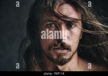 Emotive portrait of a handsome young man with hair across his face Stock Photo
