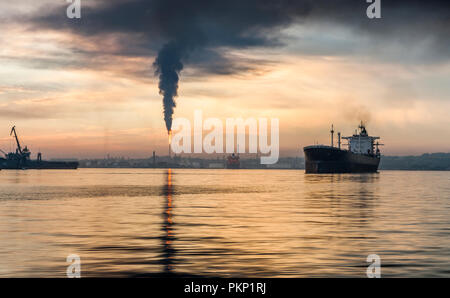 Havana, Cuba. 15th June, 2011. The oil tanker Dart departs from the port early in morning as smoke bellows from the Nico Lopez oil refinery in Havana, Stock Photo