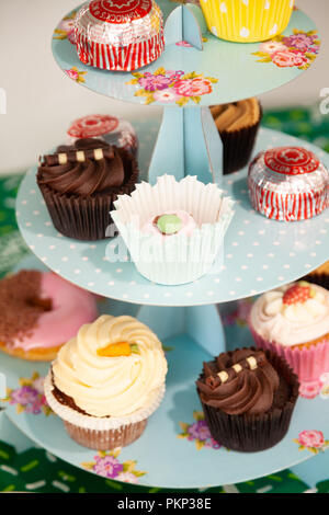 A collection of cupcakes on a cardboard cake stand. Stock Photo