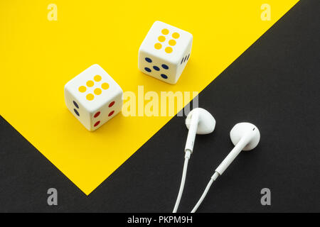 Dice and headphones on a black and yellow background Stock Photo