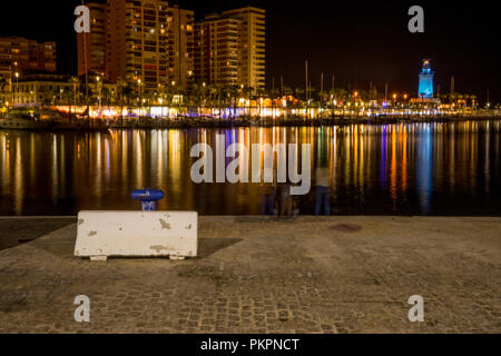 Spain, Malaga, Europe, a body of water with a city in the night sky Stock Photo