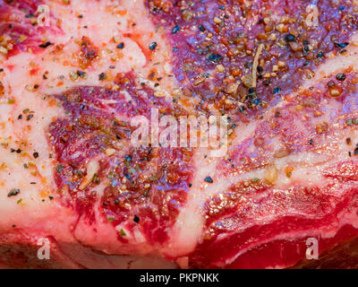 Close up shot of a big Tomahawk, seasoning with spices at home kitchen Stock Photo