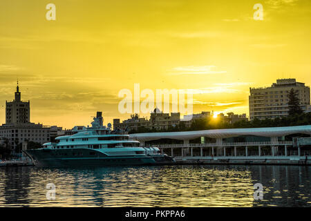 Spain, Malaga, Europe, a sunset over a body of water with a city in the background Stock Photo