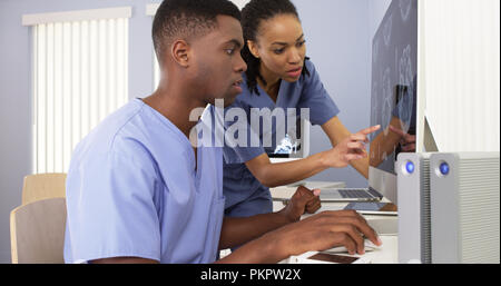 Two African American medical specialists working together on computer Stock Photo
