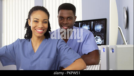 Two African American physicians sitting together by computer Stock Photo