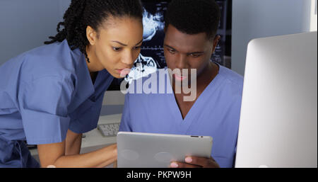 Two African American Medical specialists using computer and tablet Stock Photo