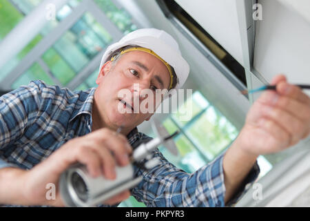 young male technician installing security camera Stock Photo