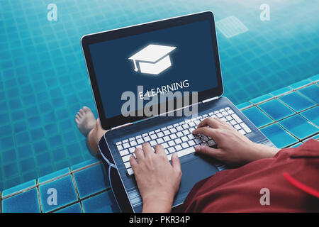 Online education, e-learning and e-book concept. a man using computer laptop for education on weekend holiday at poolside in summer Stock Photo