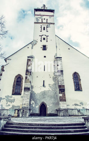 Basilica of the Holy Cross in Kezmarok city, Slovak republic. Religious architecture. Travel destination. Blue photo filter. Stock Photo