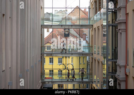 RIGA, LATVIA - JULY 18, 2018: People move between blocks of high-rise glazed buildings. Stock Photo