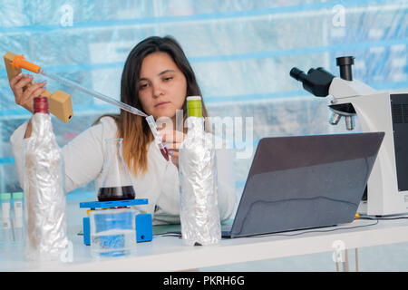 Young female technician in the quality control laboratory of wine quality inspection Stock Photo