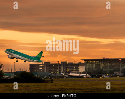Cork, Ireland. 04th August 2017. Early morning Aer Lingus flight EI866 to Barcelona takes off at sunrise from Cork Airport, Ireland. Stock Photo