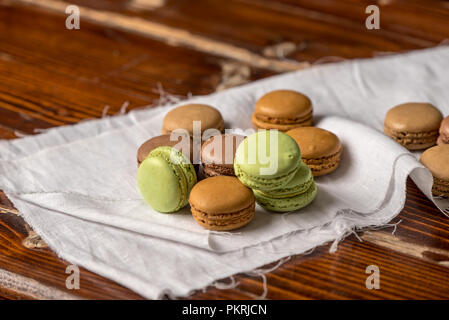 French pastries - macaroons in autumn colors on the background of an old, wooden, rustic table Stock Photo