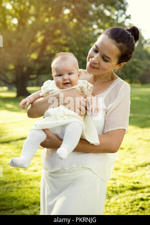 Mother holding baby girl on her hands Stock Photo