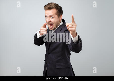 Portrait of handsome young smiling man pointing fingers at camera, picking you as winner Stock Photo