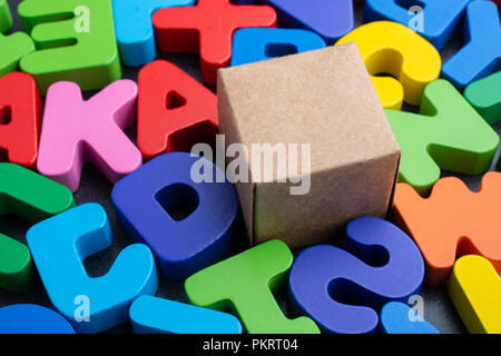 Cardboard box cube and Colorful Letters of Alphabet Stock Photo