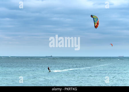 Tourists Kitesurfing on the waves of the sea the beach on a sunny day at Ninh Chu beach in Vietnam Stock Photo