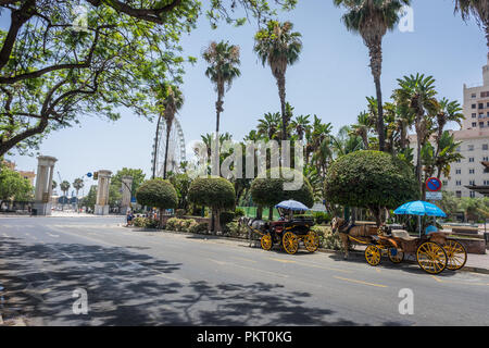 Spain, Malaga - 24 June 2017: two horse drawn carriages in front of a giant wheel at Malaga, Spain, Europe on a summer day Stock Photo