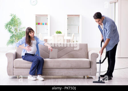 Man helping pregnant wife in cleaning Stock Photo