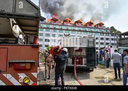 September 15, 2018 - Srinagar, J&K, India - Firefighters seen at their trucks getting all equipment to extinguish the fire on the hotel building.A massive fire erupted at a local hotel here in Srinagar on Saturday, but there was no loss of life or injury according to police. Fire tenders were rushed to the spot and police, and fire and emergency services were trying to douse the flames. Credit: Saqib Majeed/SOPA Images/ZUMA Wire/Alamy Live News Stock Photo