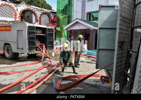 September 15, 2018 - Srinagar, J&K, India - Firefighters seen at their trucks getting all equipment to extinguish the fire on the hotel building.A massive fire erupted at a local hotel here in Srinagar on Saturday, but there was no loss of life or injury according to police. Fire tenders were rushed to the spot and police, and fire and emergency services were trying to douse the flames. Credit: Saqib Majeed/SOPA Images/ZUMA Wire/Alamy Live News Stock Photo
