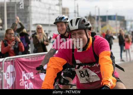 Blackpool, Lancashire, UK. 15th Sep 2018. 'Pedal to the Pier' Mencap Off road Cycling 100km Challenge. Mud spattered Competitor 84 approaches the finish line after a gruelling 60 mile charity off-road cycle ride from Manchester to Blackpool, terminating at the Tower Headland. Credit; MediaWorldImages/AlamyLiveNewsMencap Off road Cycling 100km Challenge. Mud spattered Competitor approaches the finish line after a gruelling 60 mile charity off-road cycle ride from Manchester to Blackpool, terminating at the Tower Headland. Credit; MediaWorldImages/AlamyLiveNews Stock Photo