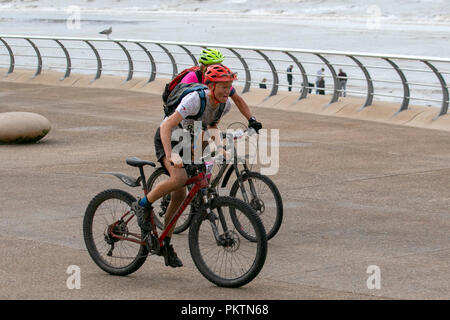 Blackpool, Lancashire, UK. 15th Sep 2018. 'Pedal to the Pier' Mencap Off road Cycling 100km Challenge. Mud spattered Competitor approaches the finish line after a gruelling 60 mile charity off-road cycle ride from Manchester to Blackpool, terminating at the Tower Headland. Credit; MediaWorldImages/AlamyLiveNewsMencap Off road Cycling 100km Challenge. Mud spattered Competitor approaches the finish line after a gruelling 60 mile charity off-road cycle ride from Manchester to Blackpool, terminating at the Tower Headland. Credit; MediaWorldImages/AlamyLiveNews Stock Photo