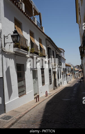 Cordoba, Spain - June 20 : Empty narrow streets with buildings on either side to offer shade on a sunny day, Andalucia Stock Photo