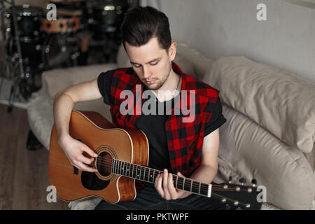 Handsome young modern man playing the guitar Stock Photo