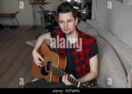 Handsome young man playing the guitar Stock Photo