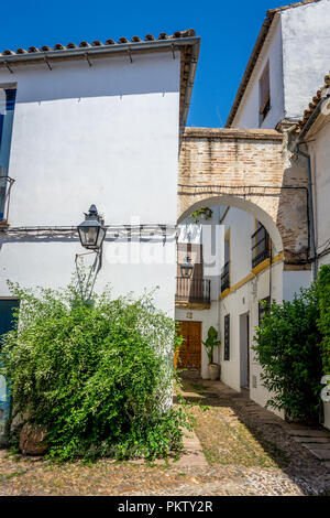 Cordoba, Spain - June 20 : An Arch on The empty streets of Cordoba on June 20, 2017 on a bright summer day with blue sky. Stock Photo